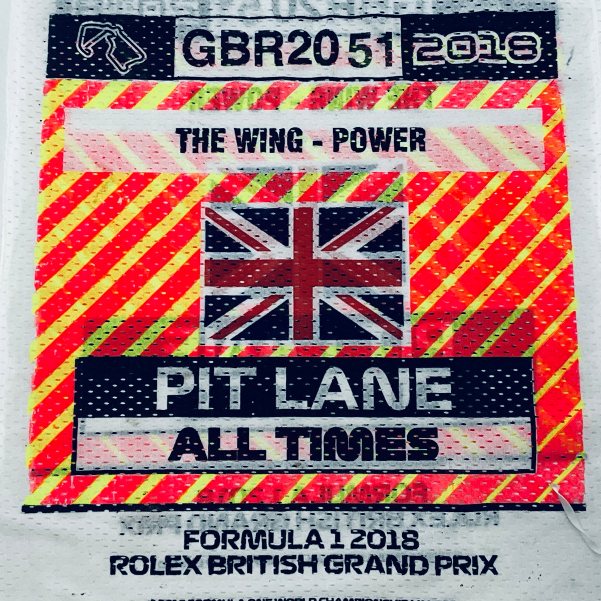 Close-up of white tabard print with Union Jack and “Pit Lane All Times”
