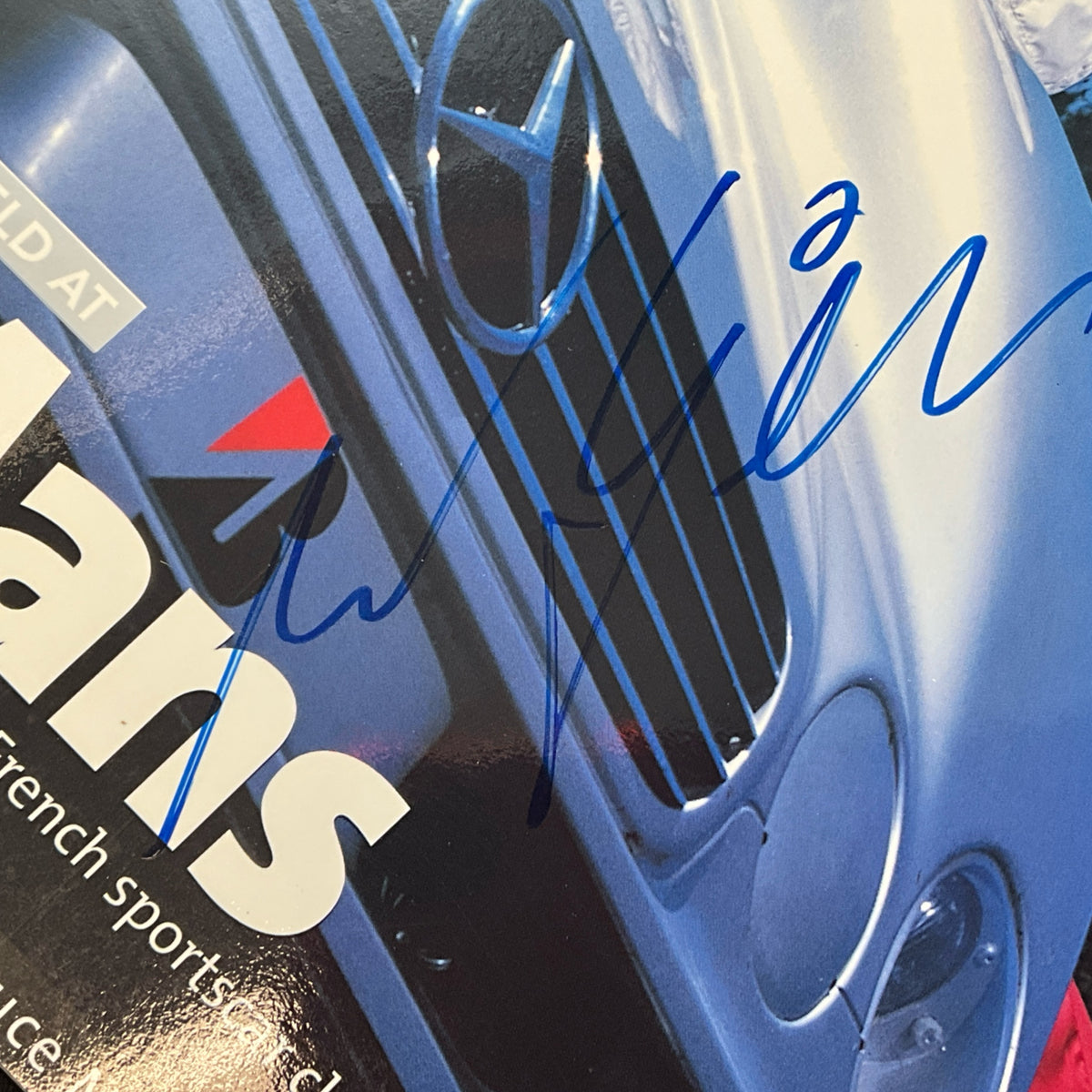Racing magazine cover close-up of blue race car headlight and grille details