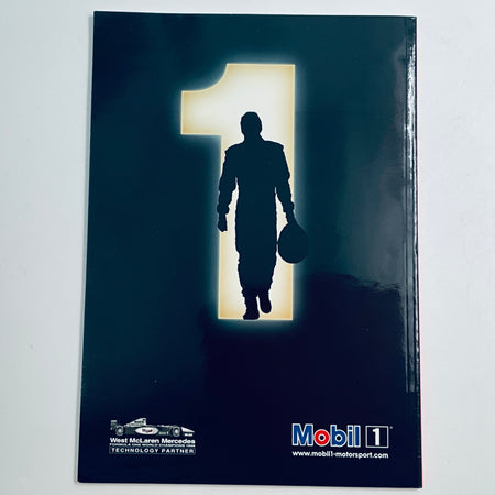 Racing magazine cover with dark silhouette of a driver holding a helmet