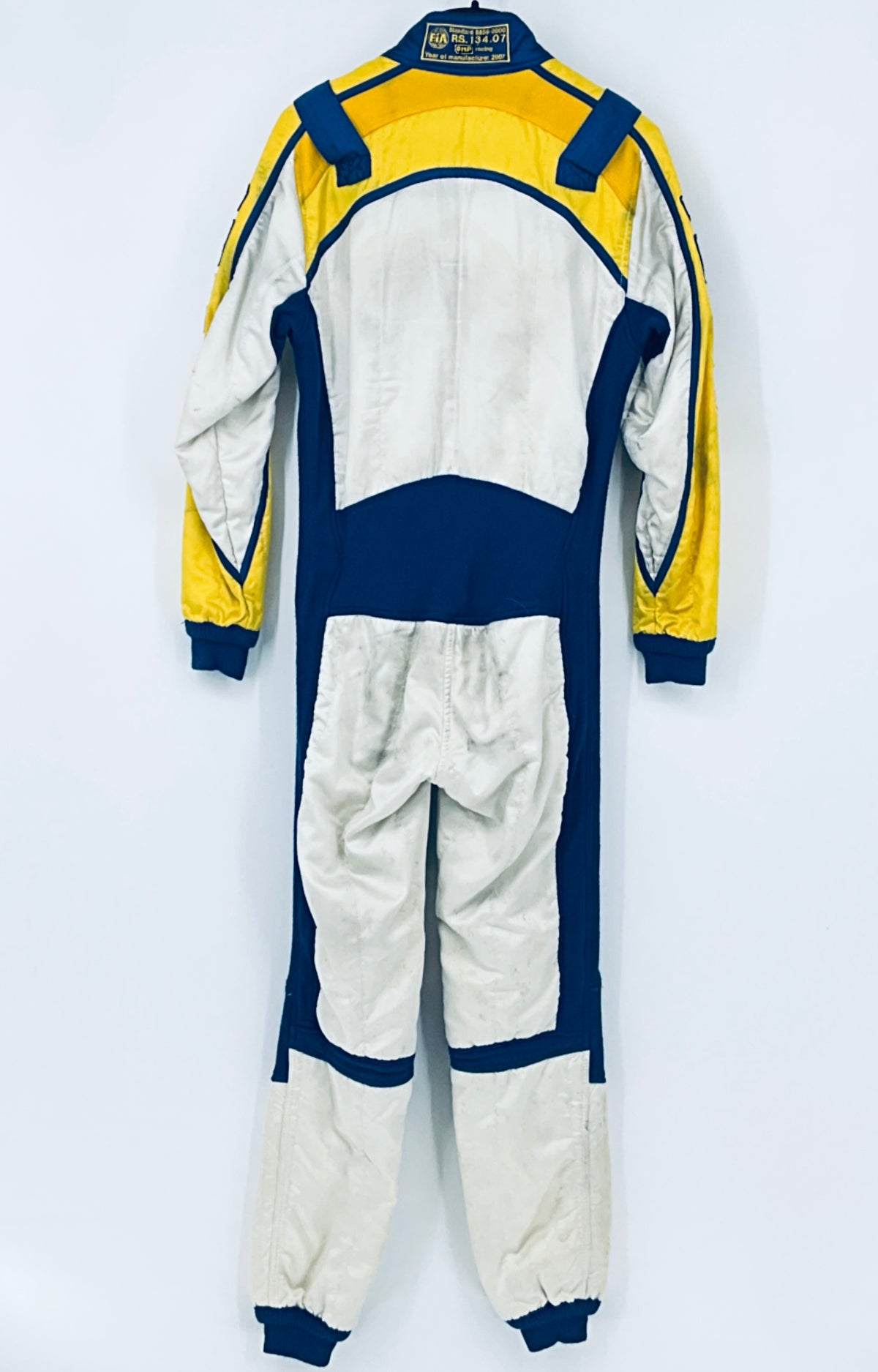 Back of race driver suit with yellow and blue shoulders and white paneling
