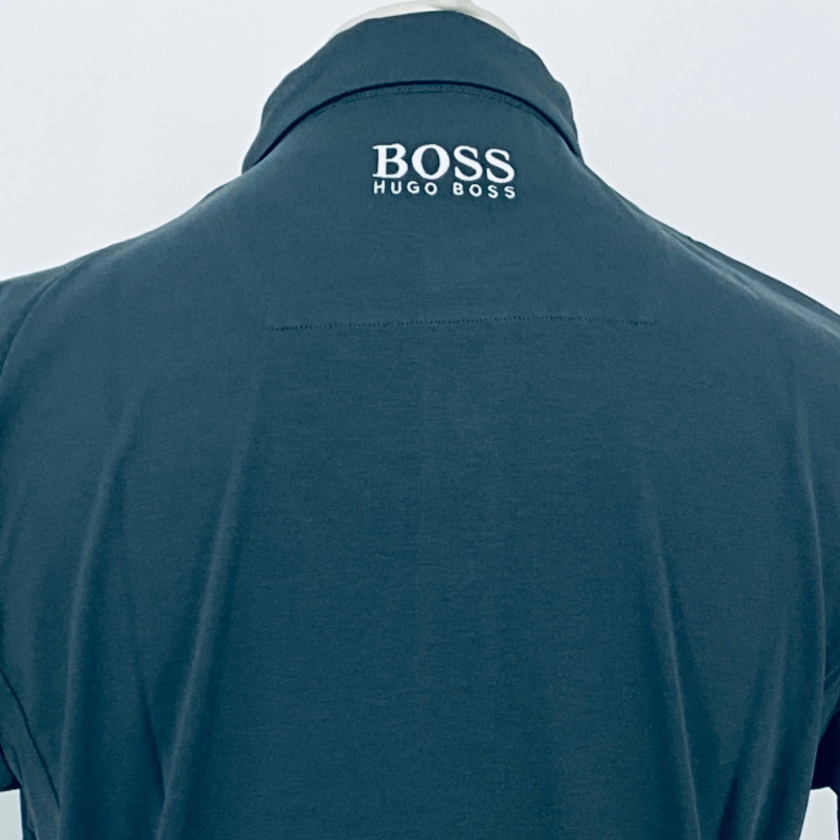 Boss polo shirt in dark teal, close-up of back collar embroidery