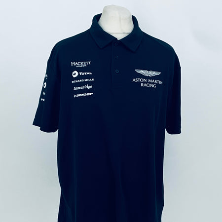 Navy Aston Martin Racing team polo shirt with sponsor logos on chest and sleeve.