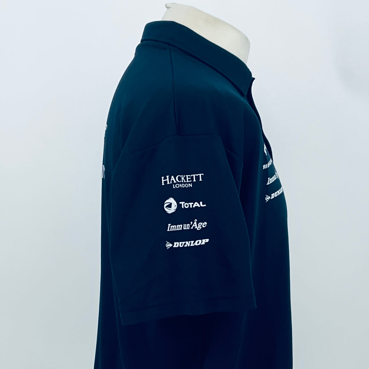 Teal Aston Martin Racing polo shirt with sponsor logos on back shoulder and sleeve.