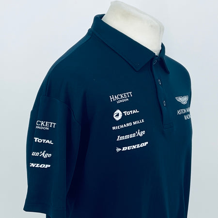 Teal Aston Martin Racing polo shirt with chest sponsor logos and wing emblem on right.