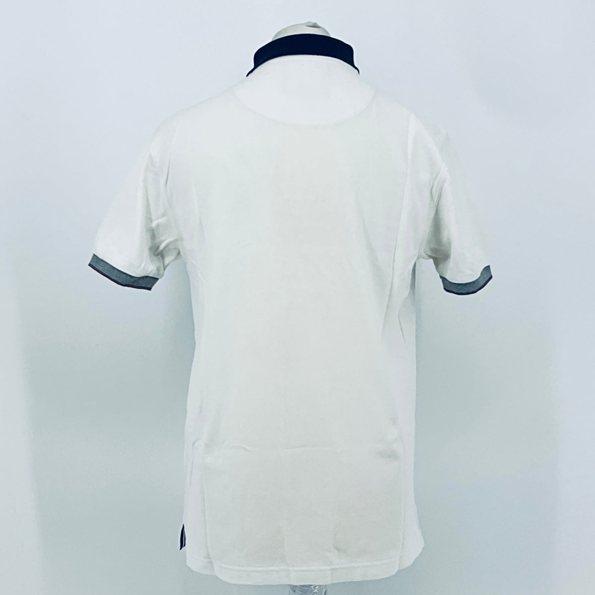 White polo shirt back view with navy collar and dark-trimmed sleeve cuffs