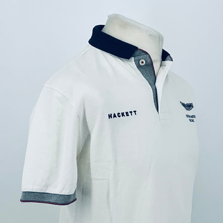 White polo shirt 3/4 front view with navy collar and Hackett chest logo