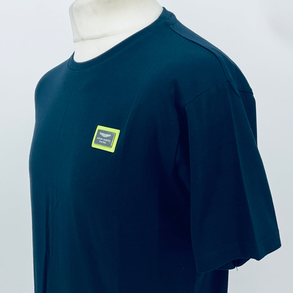 Navy T-shirt with small yellow logo patch on sleeve and chest