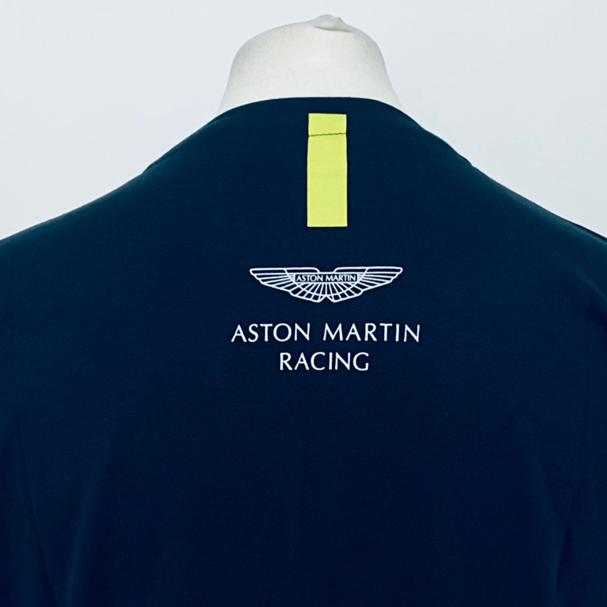 Back of navy T-shirt with Aston Martin Racing logo and vertical yellow stripe