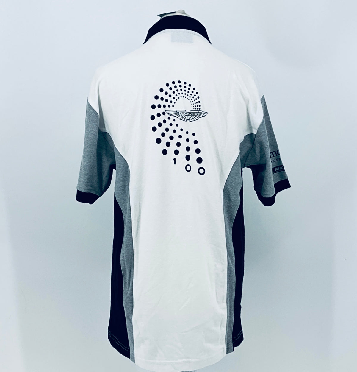 Back of white polo shirt with navy collar, gray sleeves, large dotted Aston Martin logo