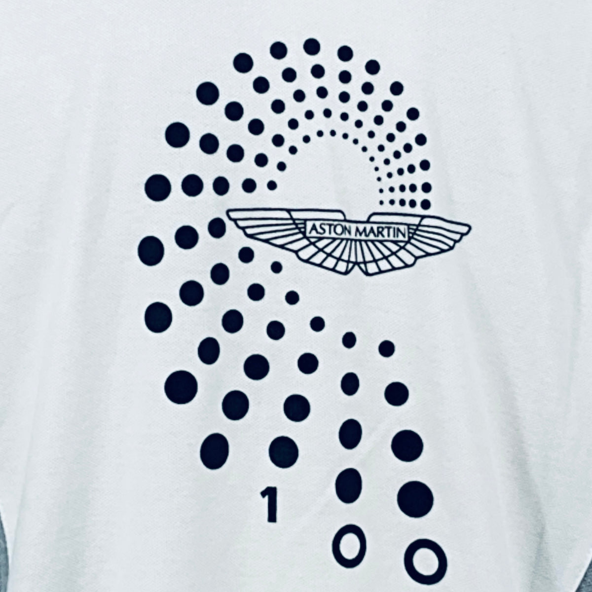 Close-up of dotted Aston Martin wing logo on back of white polo shirt