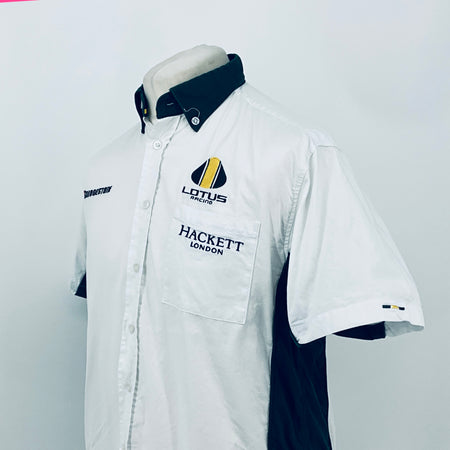 White short-sleeve button shirt with dark collar and front chest pocket logos