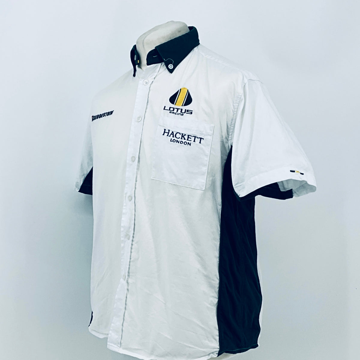 White short-sleeve button shirt with dark collar, chest pocket, and side panel detail