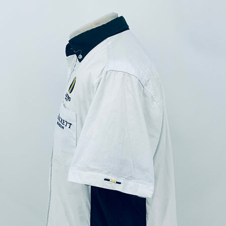 White short-sleeve button shirt with dark collar and sleeve logo patch on side view