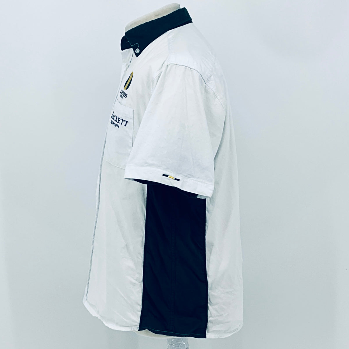 White short-sleeve button shirt with dark under-sleeve panel and small chest logo