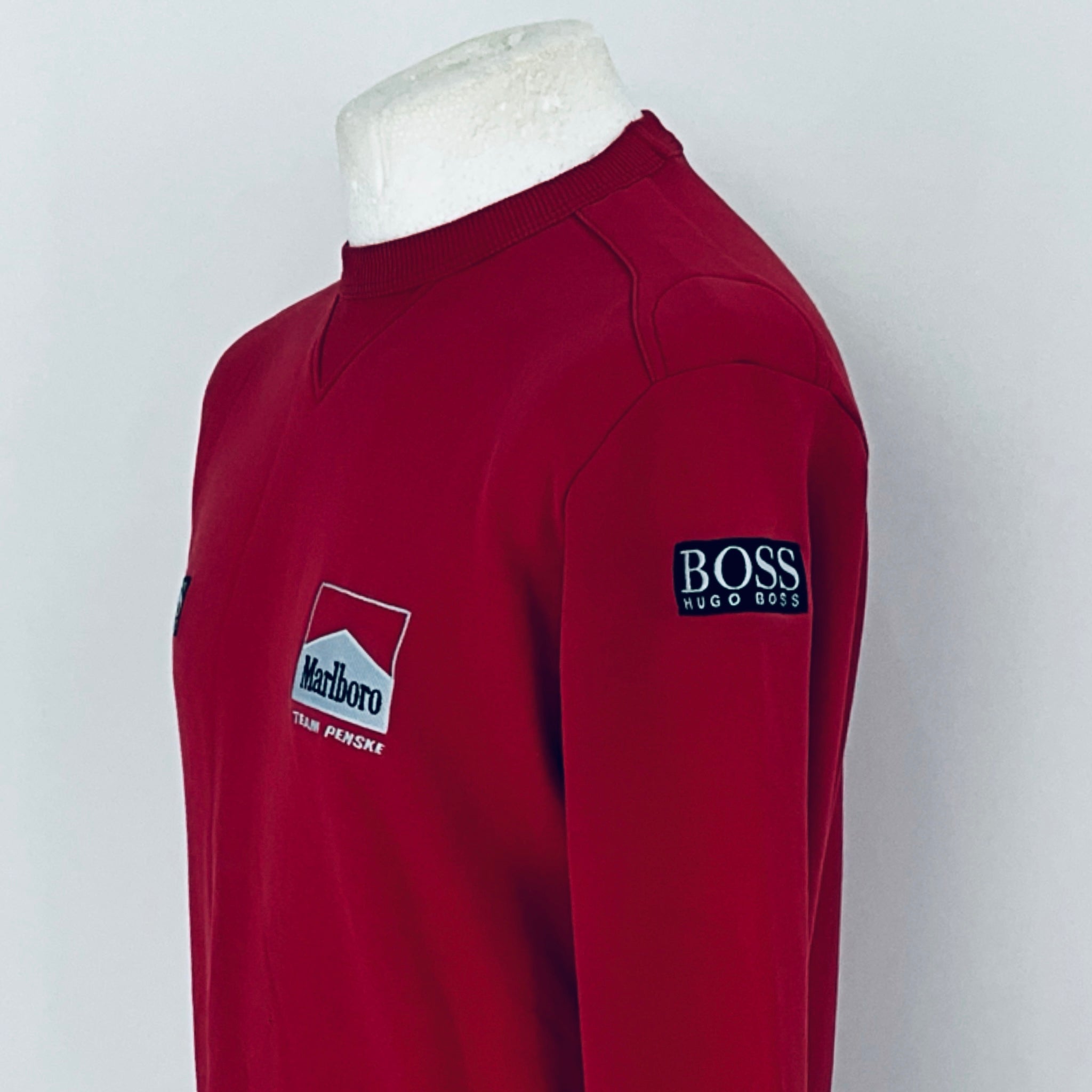 Red sweatshirt with Marlboro and Boss logos on a mannequin against a white background
